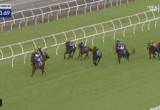 Seven horses race on a green turf track with white rails; timer reads 1:23.69 at top-left and a live broadcast logo at top-right.