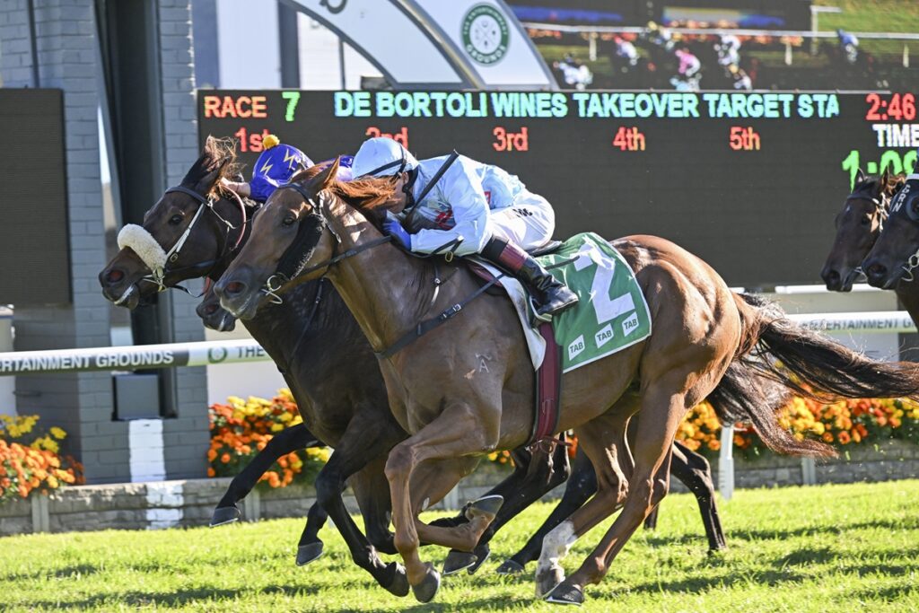 Three racehorses neck-and-neck down the track, jockeys leaning forward in a photo finish moment with a scoreboard in the background.] ,Not good--Oops