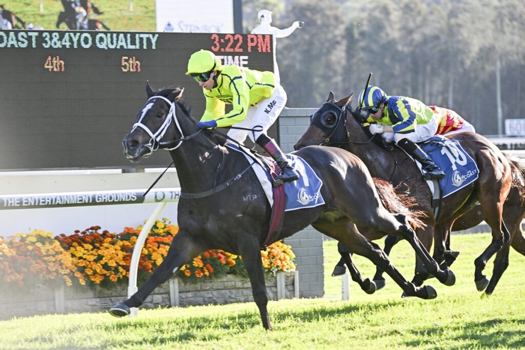 Leading jockey in neon yellow silks on a black horse, sprinting to the finish as two rivals race close behind.