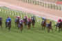 Horse race on a green turf track with jockeys in colorful silks and white railings, Racing.com Live banner in the corner.