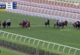 Horse race on a turf track with jockeys in colorful silks; race timer and distance graphics appear in the top-left, with a live broadcast watermark in the top-right.