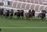 Pack of jockeys on thoroughbreds sprinting down a turf racecourse, with a blue race overlay showing times and '330m TO GO' in the top-left corner of a live broadcast.