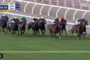 Pack of jockeys on thoroughbreds sprinting down a turf racecourse, with a blue race overlay showing times and '330m TO GO' in the top-left corner of a live broadcast.