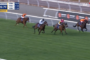 Horse race on a grass track with four jockeys sprinting; leader in orange, others close behind; signage shows 160m to go (Flemington R2).