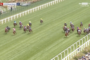 Horse race on a green turf track at Royal Ascot, several riders in colorful silks chasing the lead.