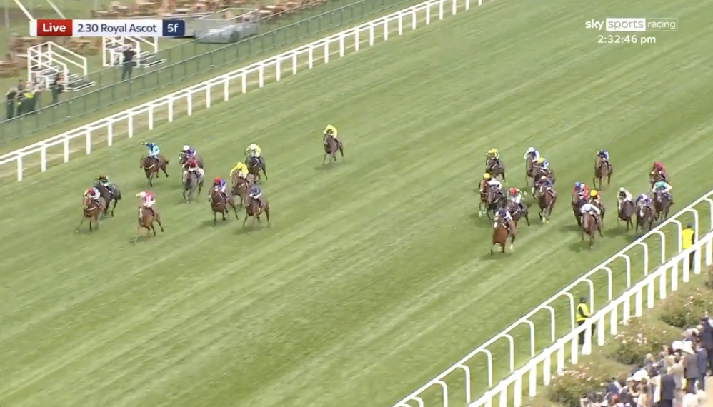 Horse race on a green turf track at Royal Ascot, several riders in colorful silks chasing the lead.